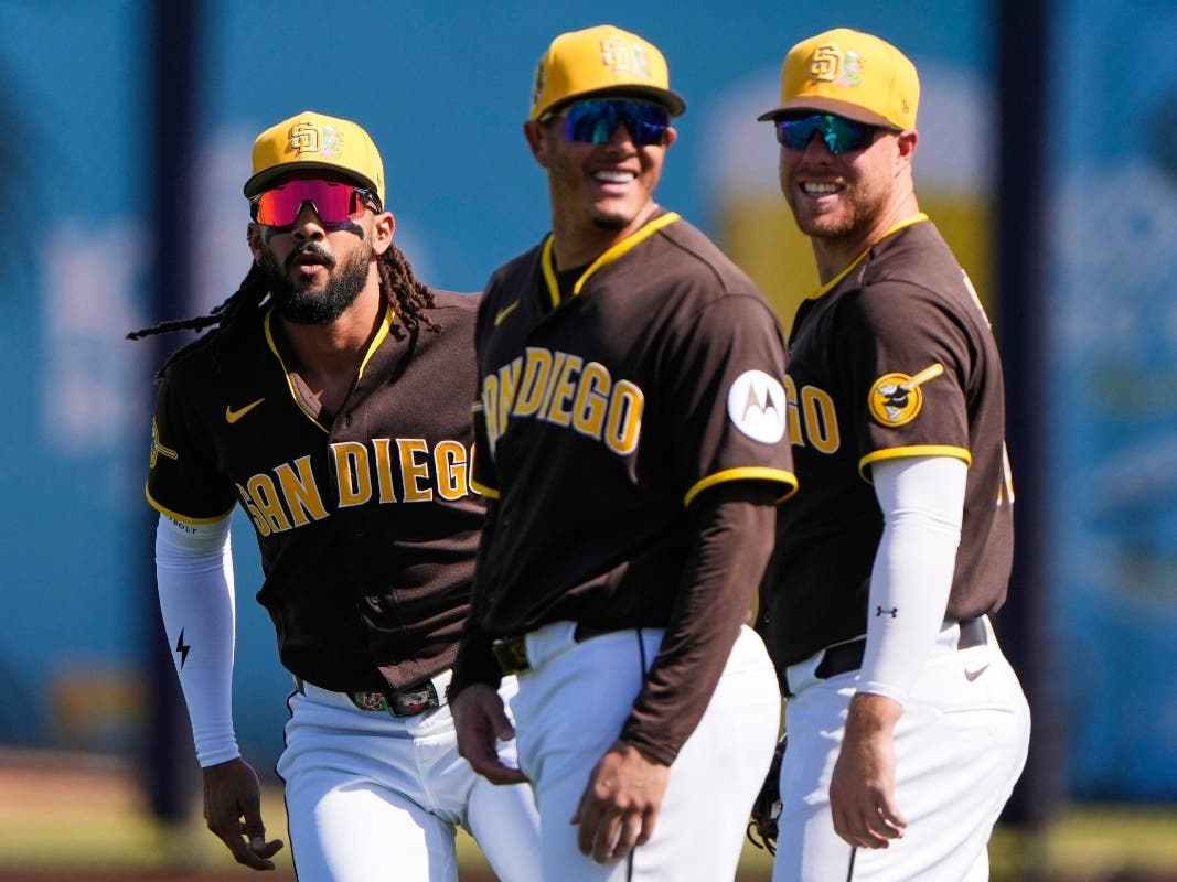 San Diego Padres' Manny Machado, center, Fernando Tatis Jr., left, and Gavin Sheets, right, talk before a spring training baseball game against the Los Angeles Angels, Wednesday, Feb. 25, 2026, in Peoria, Arizona.