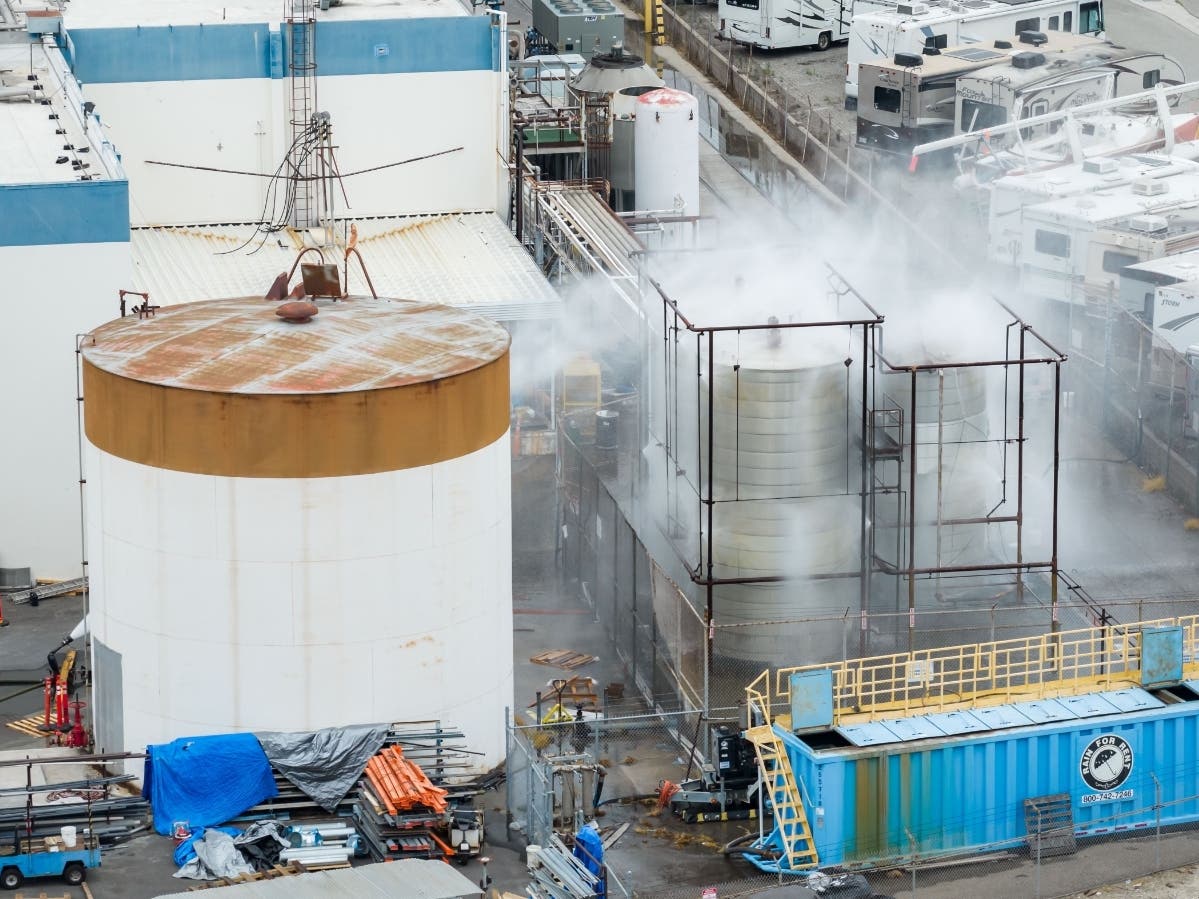 Water is sprayed on a damaged tank at GKN Aerospace in Garden Grove, Calif., on Sunday, May 24, 2026, after the tank containing a chemical used to make plastic parts overheated Thursday.