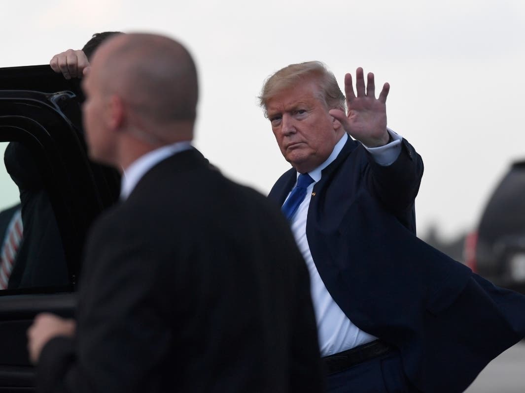 President Donald Trump waves before getting into his vehicle after arriving at Palm Beach International Airport in West Palm Beach, Fla., Friday, Jan. 17.