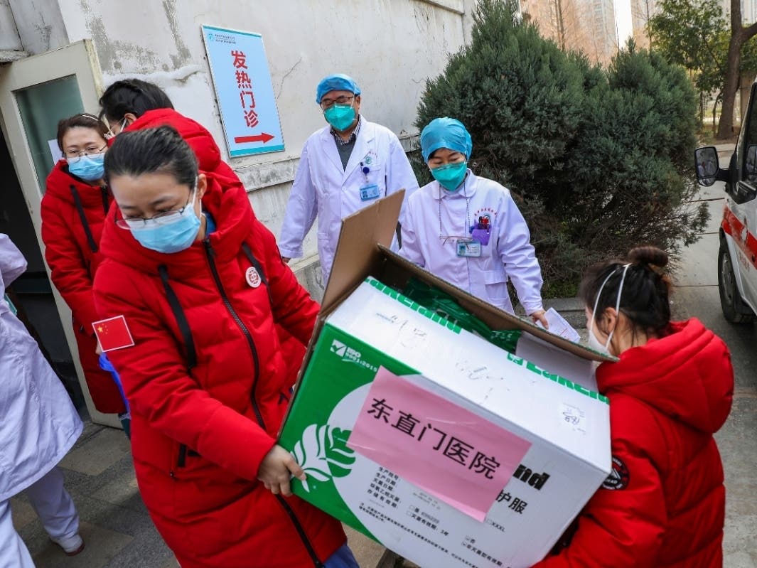 Doctors watch as donated medical supplies from Beijing are unloaded at a hospital in Wuhan in central China's Hubei Province.