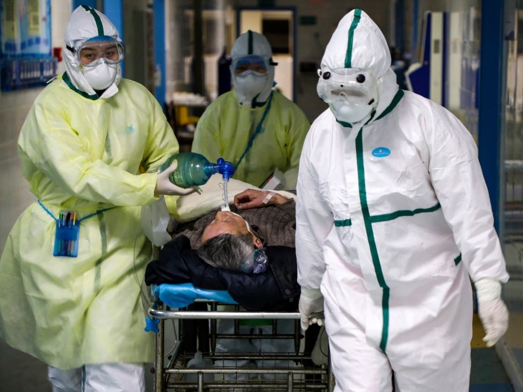Medical workers in China transfer a patient in the isolation ward for coronavirus patients in Wuhan, China. A 60-year-old woman from the United States has died from coronavirus at a hospital in China, according to reports.