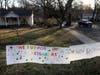 A sign showing support for neighbors is displayed on a lawn in New Rochelle, New York, the location of the largest cluster of coronavirus cases in the nation.
