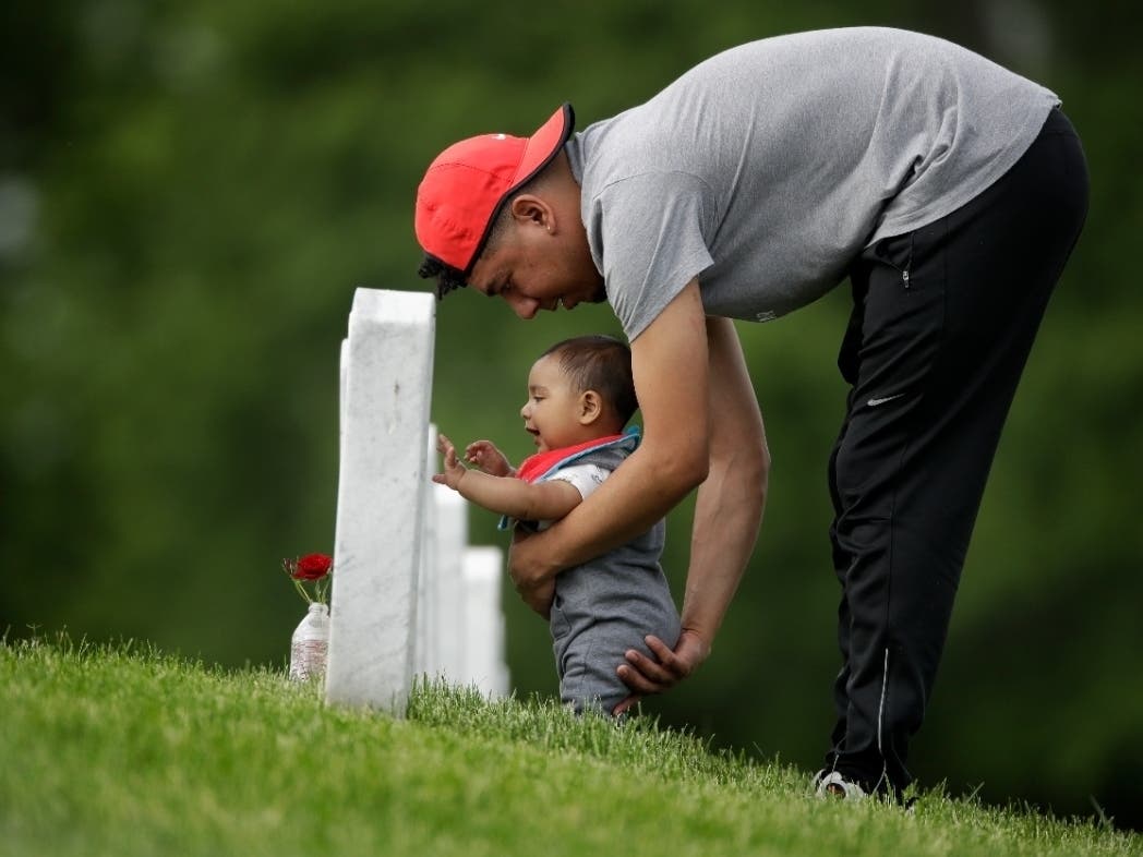 Angel Garcia-Metcalf and his son visit the boy's great-grandfather's grave at Leavenworth National Cemetery Saturday.  They were among a handful of people who decided to visit to the cemetery today instead of Memorial Day to beat the crowd.