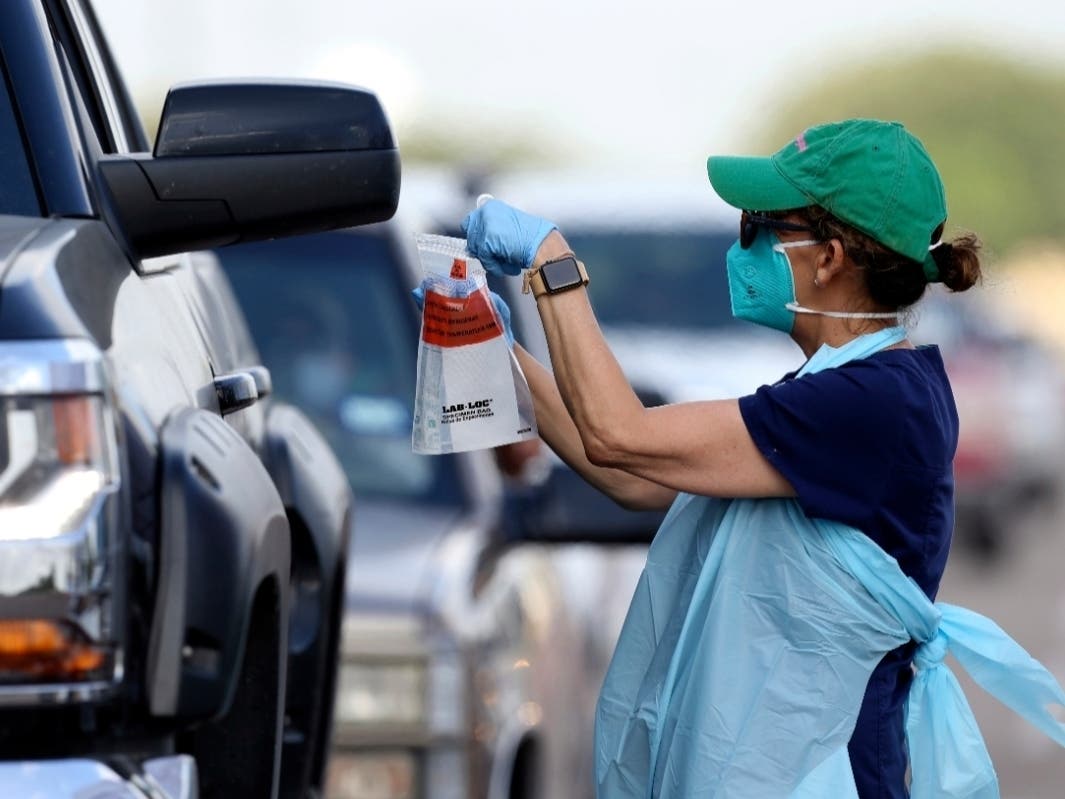 Health officials and members of the military assist during COVID-19 testing at HEB Park in Edinburg, Texas.
