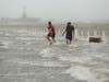 Two men walk on a flooded road as Hurricane Hanna makes landfall, Saturday, July 25, 2020, in Corpus Christi, Texas. 