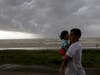 People walk along Seawall Boulevard as a band of heavy rain and wind approaches, Saturday, July 25, 2020, in Galveston, Texas.