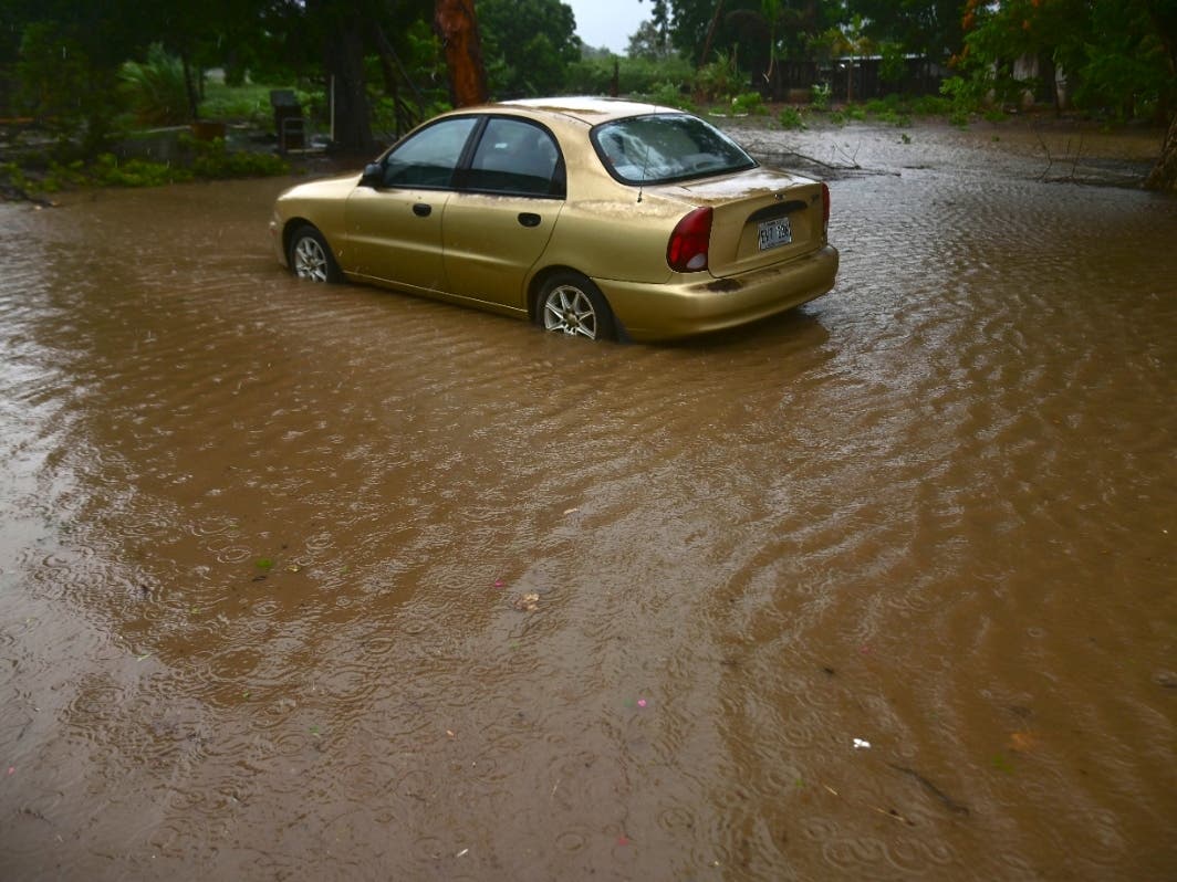 A car sits in flood waters caused by Tropical Storm Laura in Salinas, Puerto Rico.