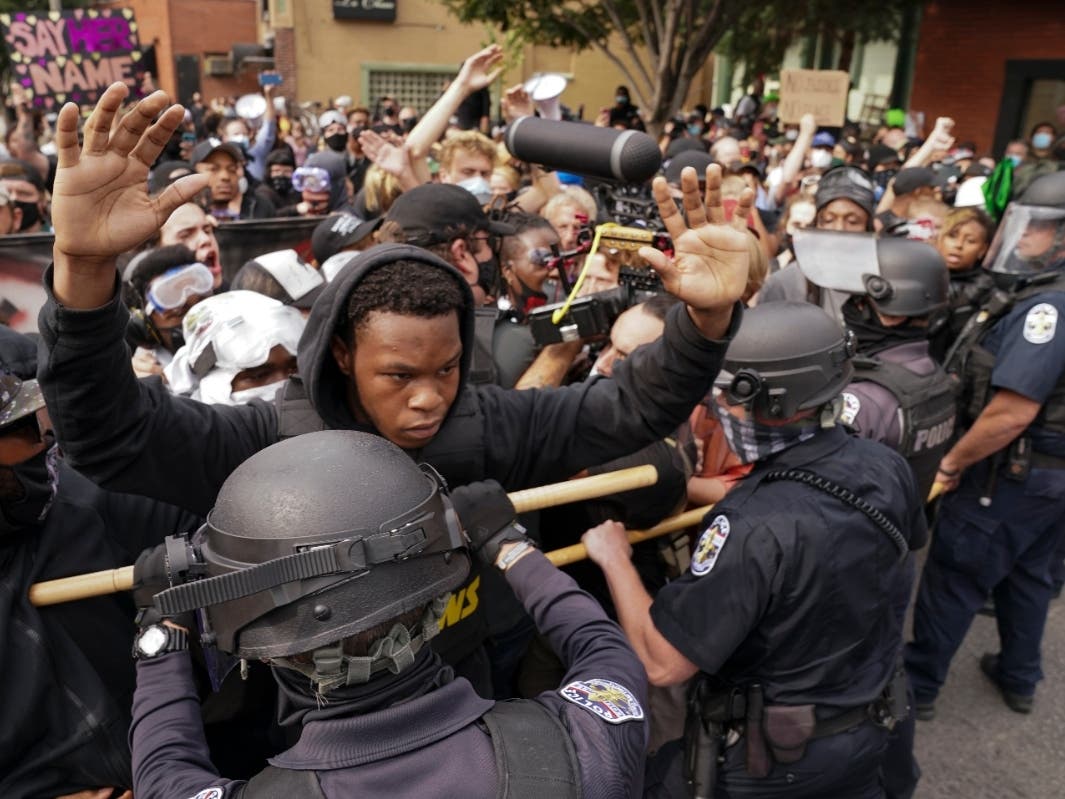 Police and protesters converge during a demonstration Wednesday in Louisville, Ky. A grand jury has indicted one officer on criminal charges six months after Breonna Taylor was fatally shot by police in Kentucky. 