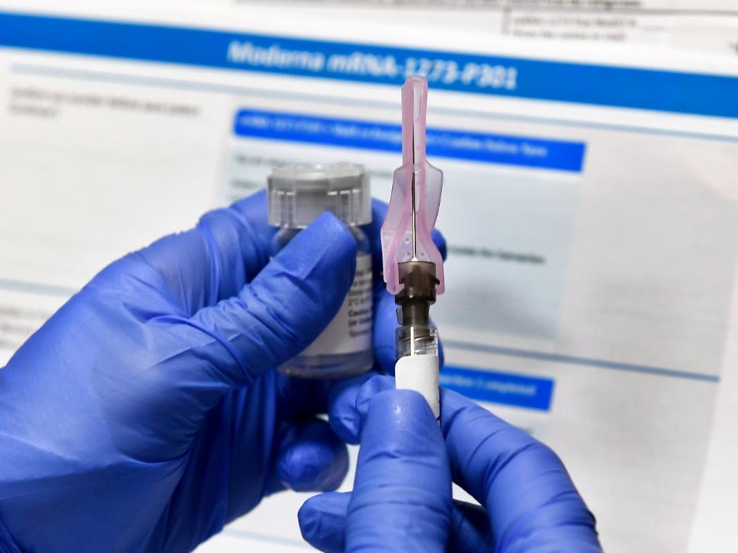 In this July file photo, a nurse prepares a shot as a study of a possible COVID-19 vaccine, developed by the National Institutes of Health and Moderna Inc., gets underway in Binghamton, N.Y.