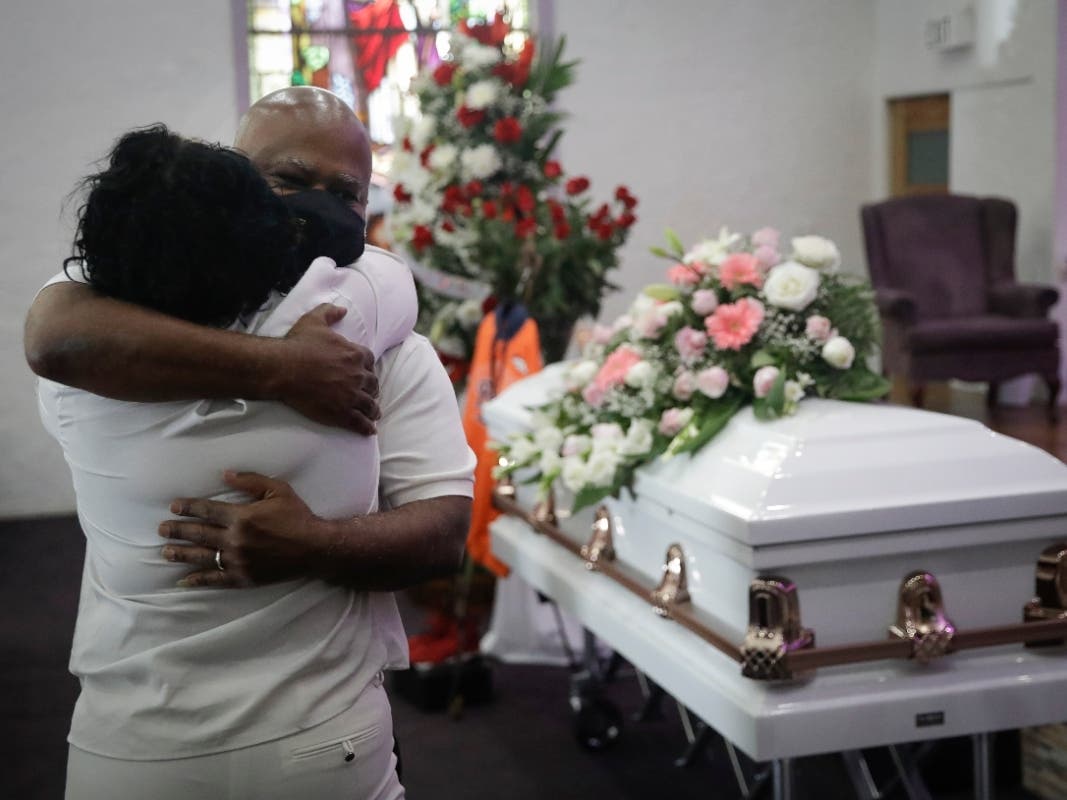 In this July file photo, Darryl Hutchinson, facing camera, is hugged by a relative during a funeral service for Lydia Nunez, who was Hutchinson's cousin at the Metropolitan Baptist Church in Los Angeles.