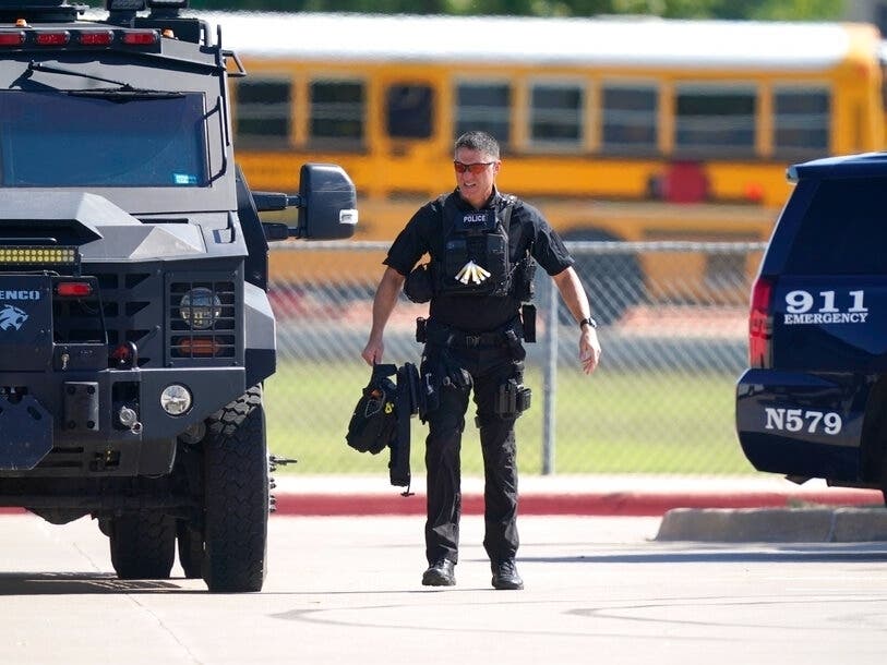 A law enforcement officer walks in the parking lot of Timberview High School after a shooting inside the school in south Arlington, Texas.