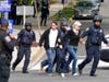 Police evacuate people near the scene of a shooting Friday in Washington, D.C. Police say at least three people were injured and police are searching for a person of interest, Raymond Spencer of Fairfax.