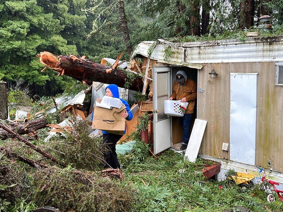 Family friends remove items from the mobile home where 2-year-old Aeon Tocchini was killed by a fallen redwood tree in Occidental, California.