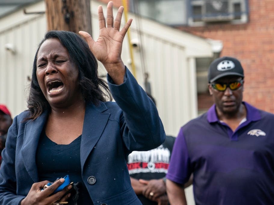 Pastor Ebony Harvin leads a prayer gathering at the site of the July mass shooting in the Southern District of Baltimore. The shooting killed two young people and injured more than two dozen others.