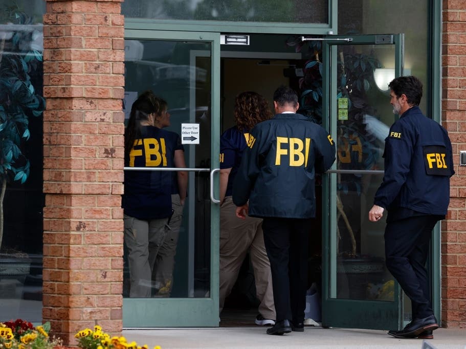 FBI personnel enter a building in Portsmouth on Wednesday, May 6, 2026.