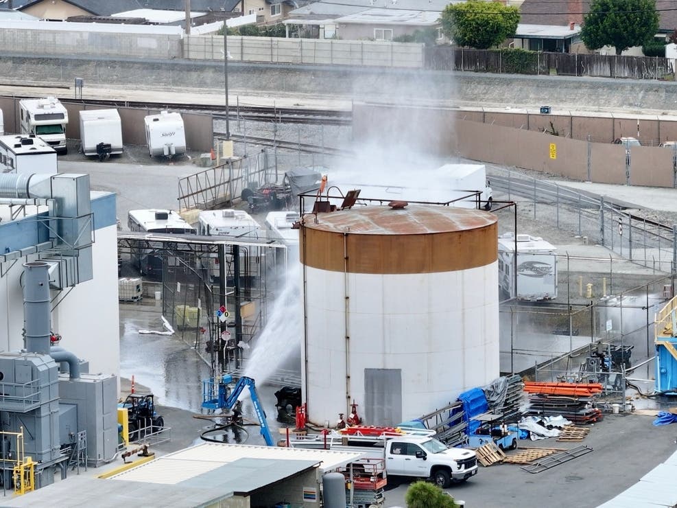 Water is sprayed on a tank that overheated at an aerospace plant in Garden Grove on Friday.