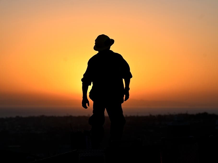 A firefighter stands on the roof of his engine as he prepares to leave the Norte Fire on Friday, Oct. 16, 2026, in San Juan Capistrano, Calif.
