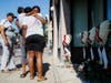 Family members of slain mass shooting victim Thomas "TJ" McNichols, from left, Donna Johnson, aunt, and sisters Jamila and Finesse McNichols, mourn beside a memorial near the scene of the shooting Monday, Aug. 5, 2019, in Dayton, Ohio.