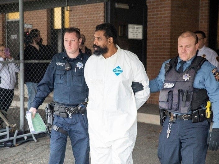 Ramapo police officers escort Grafton Thomas from Ramapo Town Hall to a police vehicle, Dec. 29, 2019. Thomas is accused of stabbing people gathered to celebrate Hanukkah at a rabbi's home.