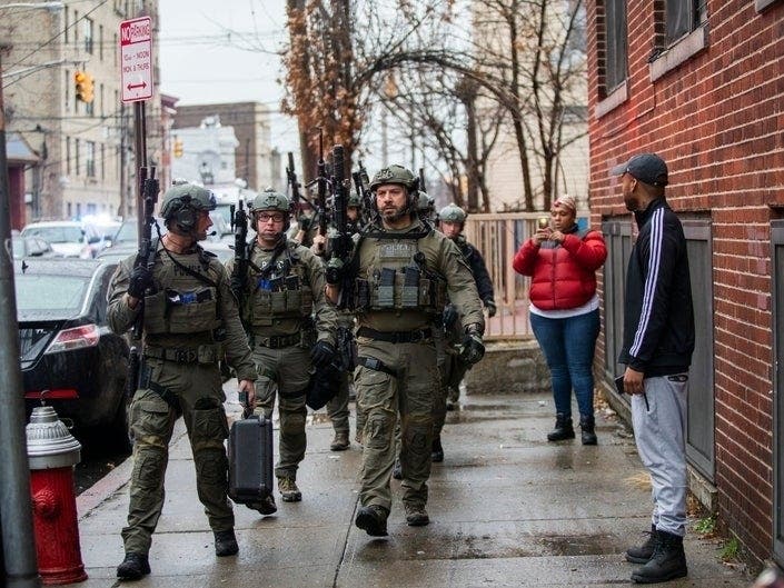 Police officers arrive at the scene following reports of gunfire in Jersey City, New Jersey.