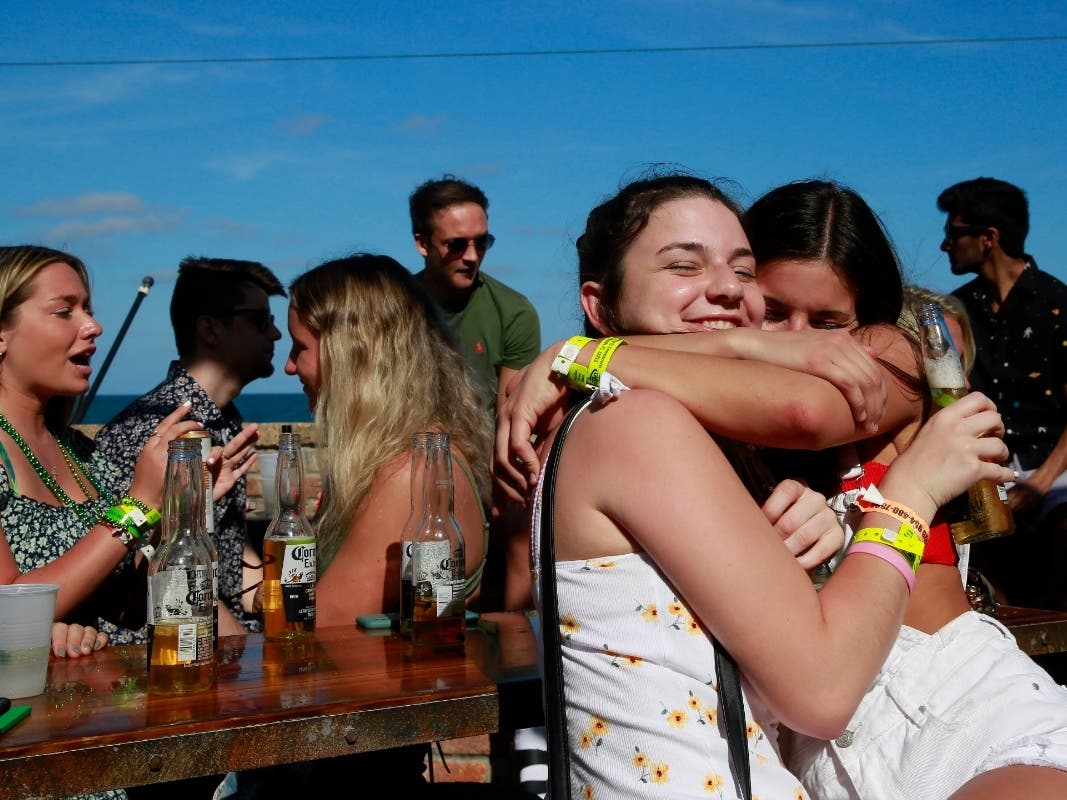 Laura Haverty, left, and Haley Halse, both of Saratoga, N.Y., hug at McSorley's Beach Pub onTuesday, March 17, 2020, in Fort Lauderdale Fla. 