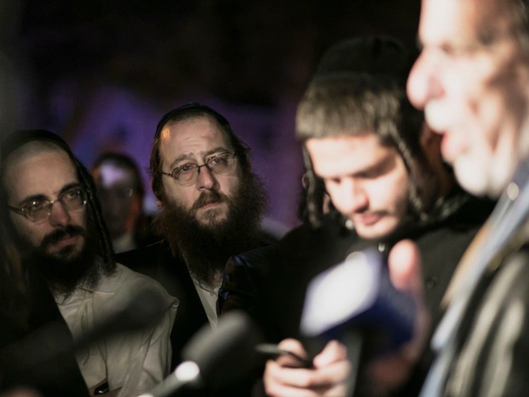 Orthodox Jewish men listen to N.Y. state Assemblyman Dov Hikind speak in Monsey, N.Y., Sunday, Dec. 29, 2019, following a stabbing late Saturday during a Hanukkah celebration. 