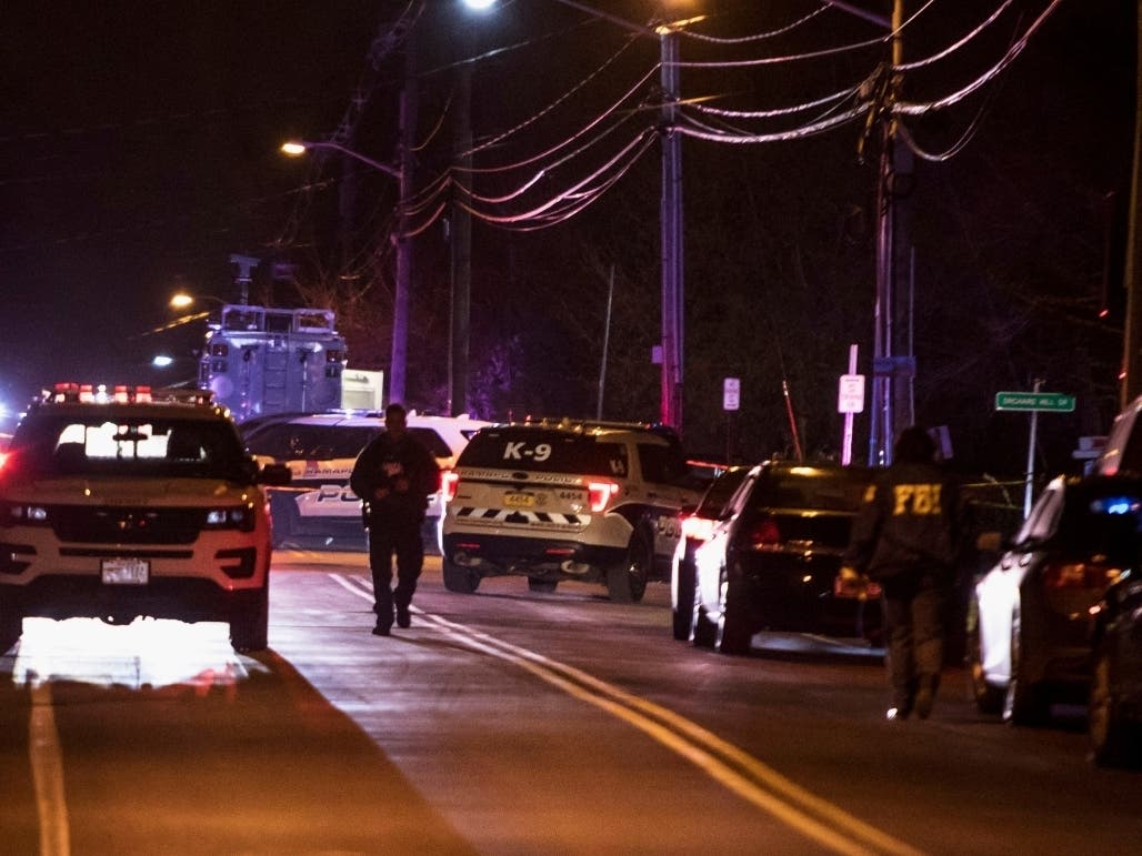 Authorities gather on a street in Monsey, N.Y., Sunday, Dec. 29, 2019, following a stabbing late Saturday during a Hanukkah celebration. 