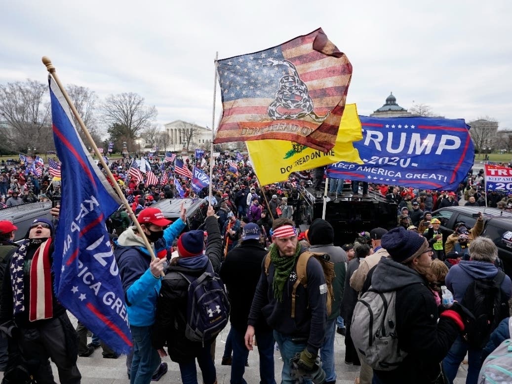 Insurrectionists loyal to President Donald Trump swarm the Capitol, Jan. 6, 2021, in Washington. More than a dozen Maryland residents face charges stemming from the attack; some fought with police and others livestreamed the violence, the FBI said.