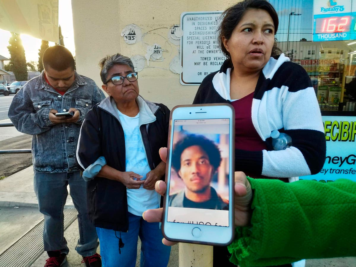 Neighbors react as they look at a cellphone picture of University of Southern California student Victor McElhaney.