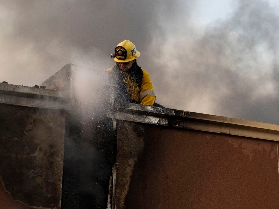 A structure firefighter works on the roof of a building during the Tick fire in the Santa Clarita area of Los Angeles, Calif. on Thursday, Oct. 24, 2019. 