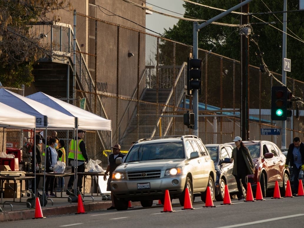 Vehicles line up at a "Grab & Go" stop to get free school meals provided by the Los Angeles Unified District at the Virgil Middle School station Los Angeles. 