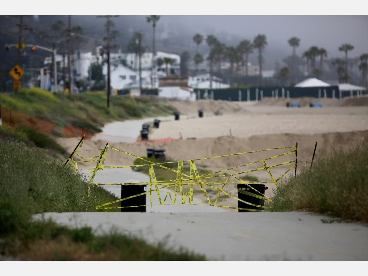 Barricades, signs and a sand berm blocking the bike path show that Will Rogers State Beach in the Pacific Palisades area of Los Angeles is one of several Los Angeles County beaches that are closed to the public due to COVID-19 restrictions.