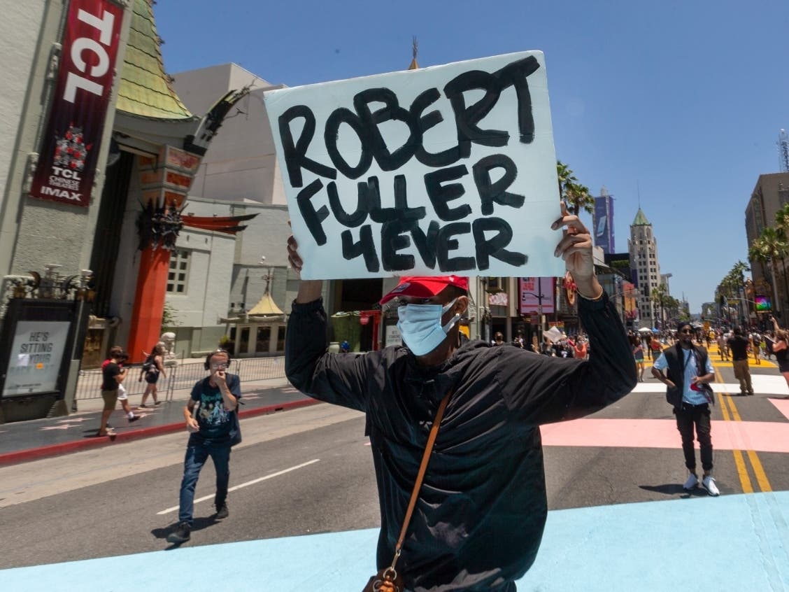 A demonstrator carries a sign reading: "Robert Fuller 4Ever" during an All Black Lives Matter march organized by black members of the LGBTQ community, in the Hollywood section of Los Angeles on Sunday, June 14, 2020. 