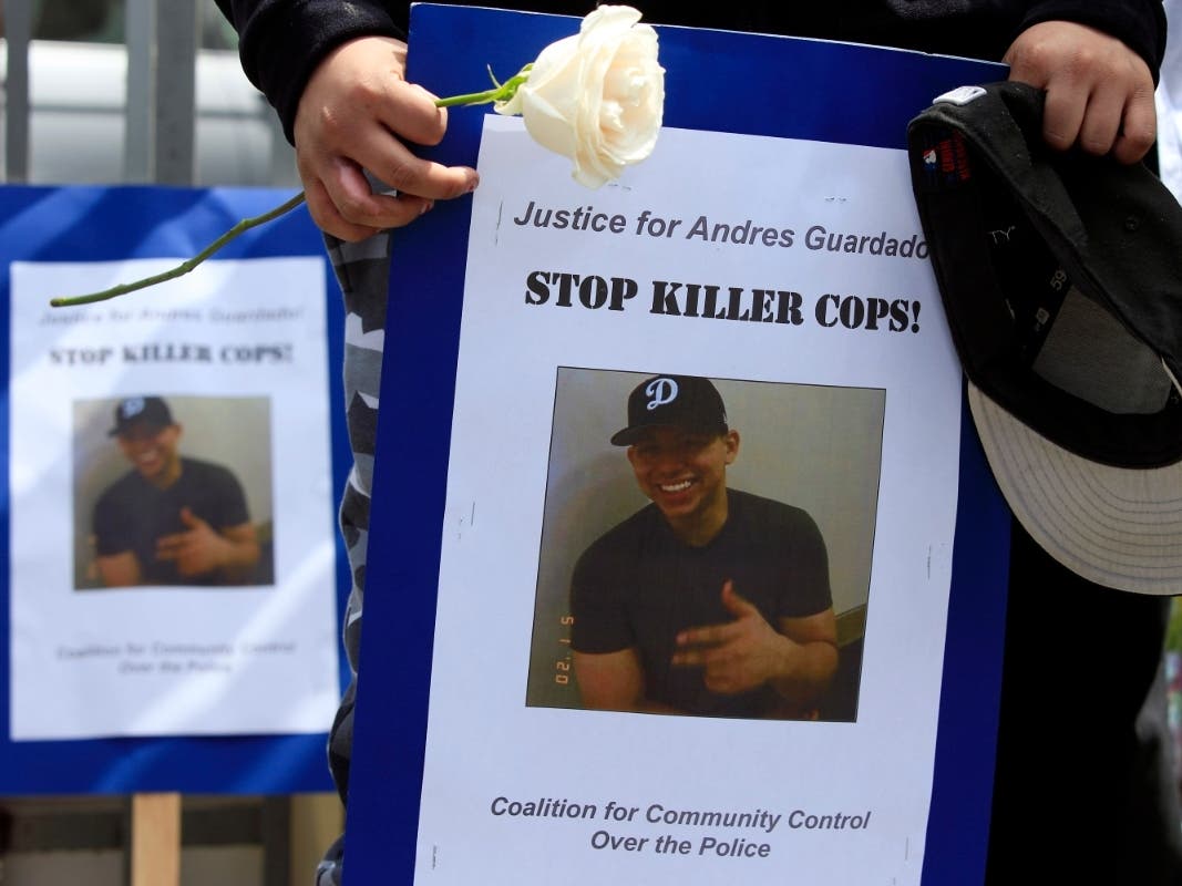 Mourners hold images of Andres Guardado, 18, who was fatally shot by a Los Angeles County sheriff's deputy, at a memorial site in Gardena, Calif., Friday, June 19, 2020.