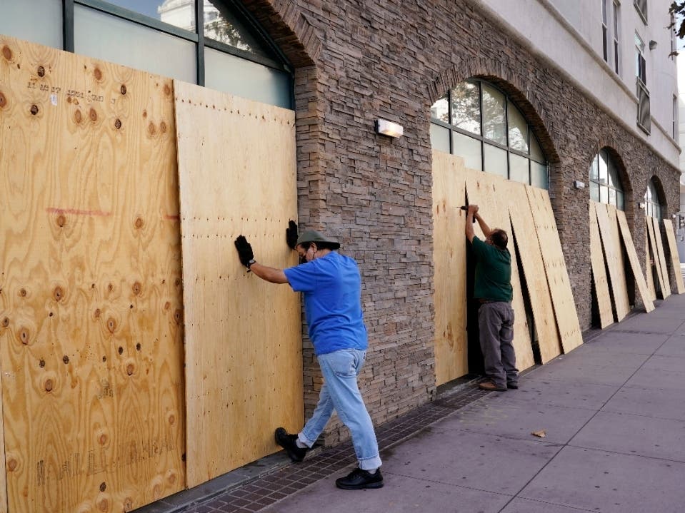 Laborers board up windows at the Le Jardin des Enfants preschool, Monday, Nov. 2, 2020, in downtown Los Angeles. Law enforcement across California is preparing for potential civil unrest in the hours during and the days following Election Day, regardless 