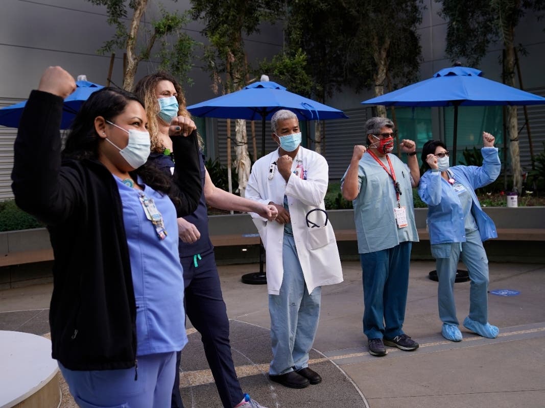 Medical staff, Helen Cordova, from left, Kim Taylor, Brian Thompson, Raul Aguilar, and Angela Balam pose for photos after receiving the Pfizer-BioNTech COVID-19 vaccine at Kaiser Permanente Los Angeles Medical Center in Los Angeles, Monday, Dec. 14, 2020.