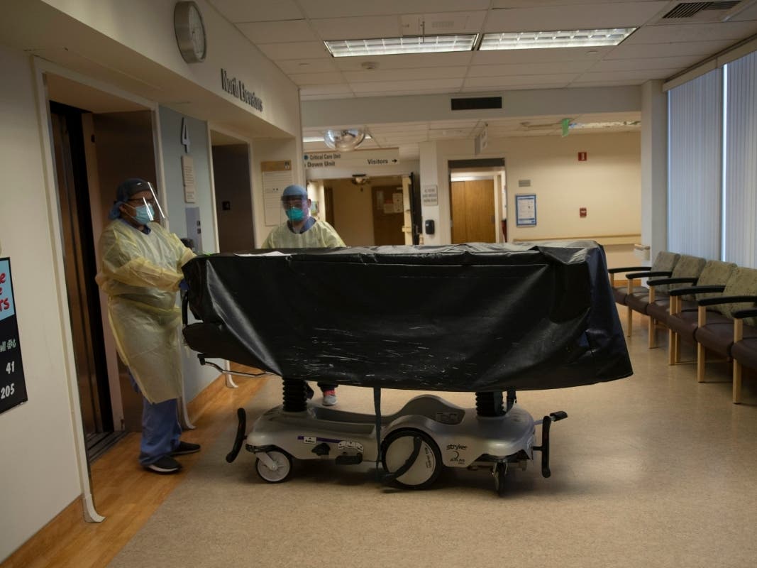  In this July 7, 2020, file photo, hospital staff members enter an elevator with the body of a COVID-19 victim on a gurney at St. Jude Medical Center in Fullerton, Calif. When Gov. Gavin Newsom provided a dire view of California's out-of-control surge.