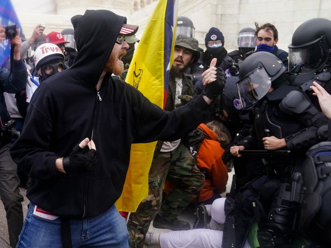  In this Jan. 6, 2021, file photo, Trump supporters try to break through a police barrier at the Capitol in Washington. In dozens of cases on social media, Trump supporters downright flaunted their activity on the day of the deadly insurrection.