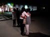 Unidentified people comfort each other as they stand near a business building where a shooting occurred in Orange, Calif., Wednesday, March 31, 2021. A shooting at a Southern California office building on Wednesday left several people dead and injured and
