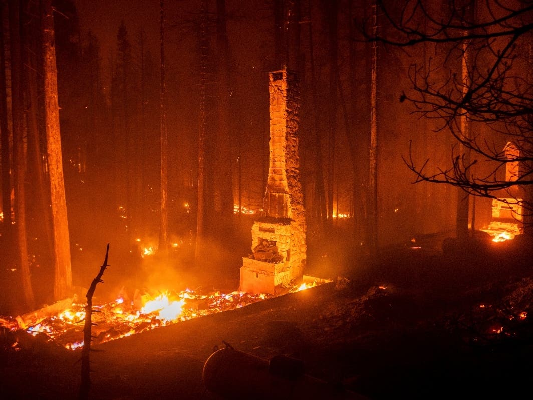 Seen in a long camera exposure, chimneys stand at residences leveled by the Caldor fire on Sunday along Route 50 in the Eldorado National Forest in California.