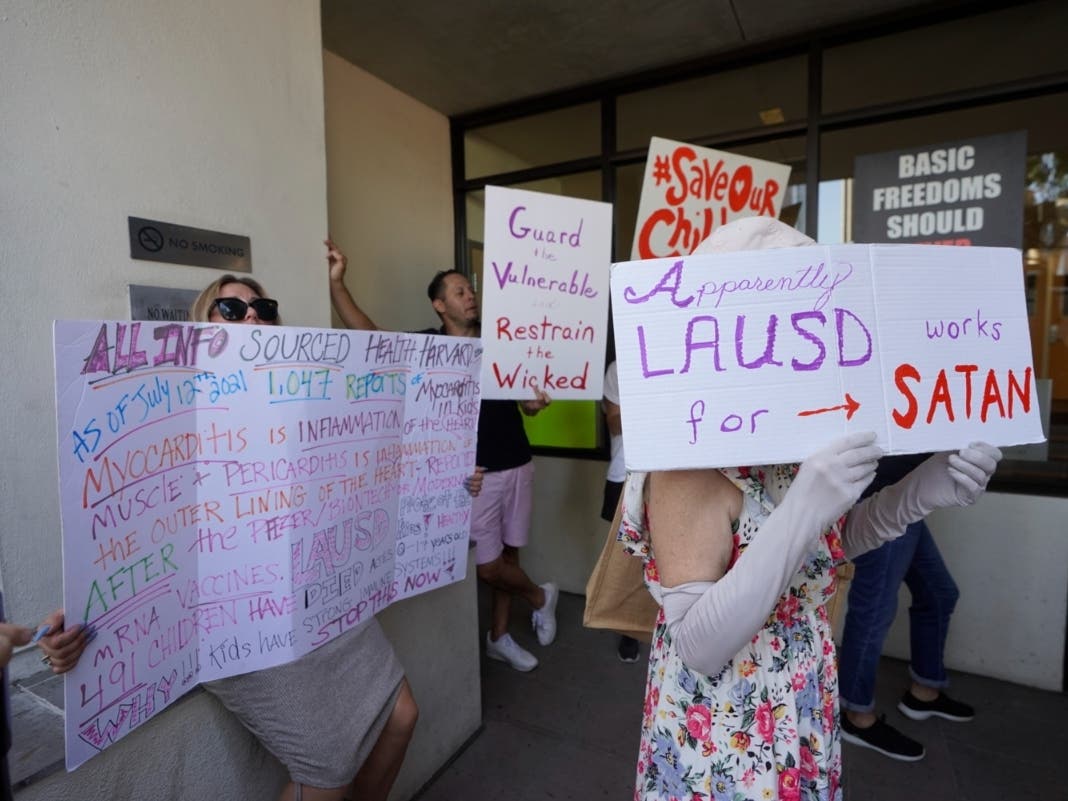 File Photo: Anti-vaccine mandate protesters hold signs outside the front doors of the Los Angeles Unified School District, LAUSD headquarters in Los Angeles.