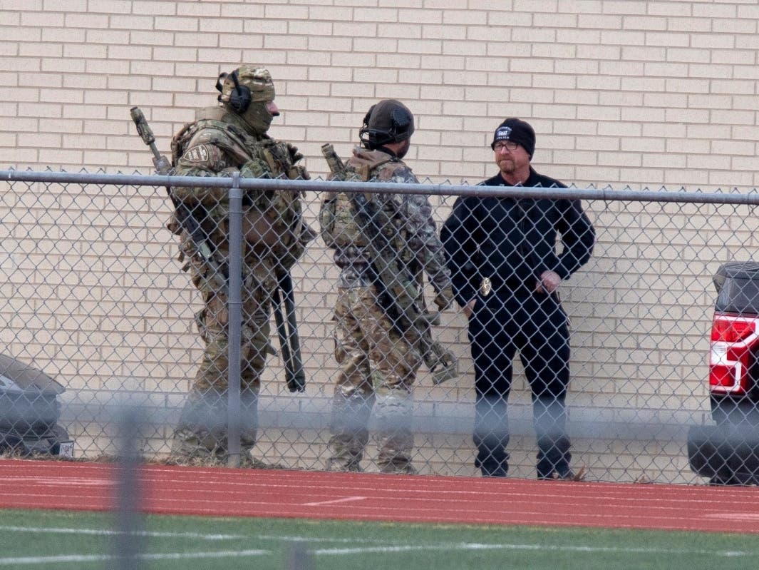 Law enforcement officials gather at a local school near the Congregation Beth Israel synagogue on Saturday, Jan. 15, 2022 in Colleyville, Texas.
