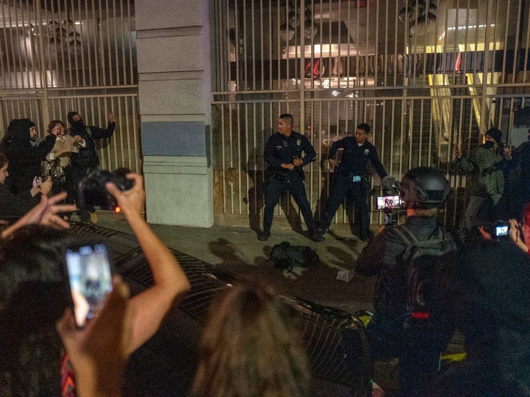 Two police officers are surrounded by a group of demonstrators near Pershing Square following a protest outside the U.S. Courthouse in response to leaked draft of the Supreme Court's opinion to overturn Roe v. Wade in Los Angeles, Tuesday, May 3, 2022. 