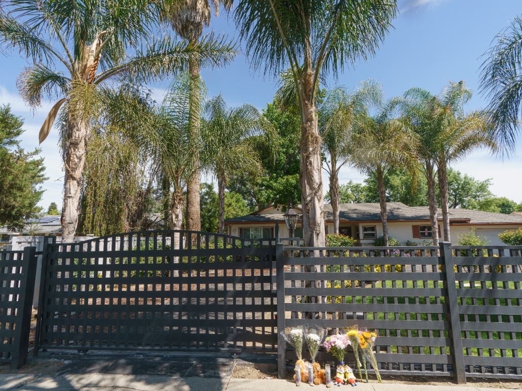 Flowers and teddy bears are left outside a ranch-style house in the San Fernando Valley, Monday. Police say three children were found dead at this Los Angeles home over the weekend and their mother and a teenager were arrested.