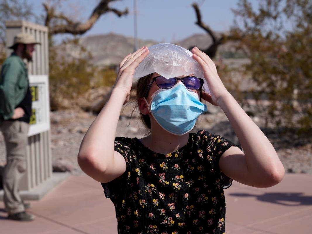 File Photo: Katie Moore holds a bag of ice on her head Monday, Aug. 17, 2020, in Death Valley National Park, Calif. Death Valley recorded a scorching 123 degrees Friday and shattered a temperature record on Saturday. 