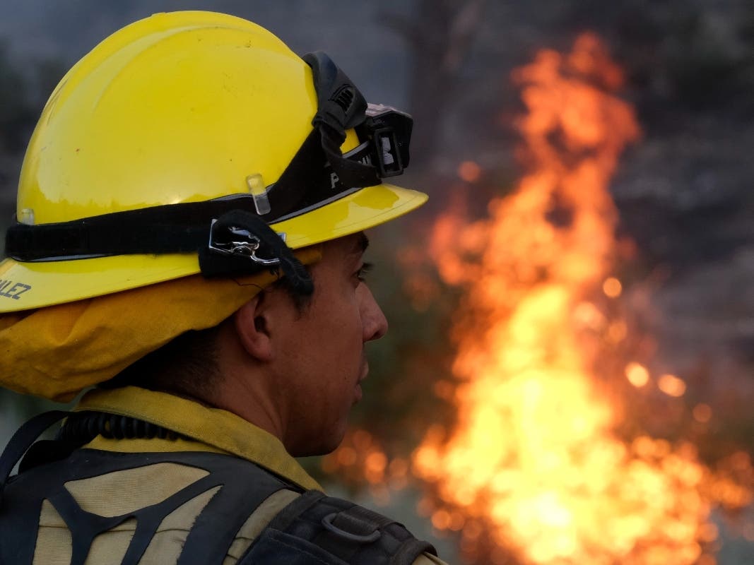 A firefighter watches as the Sheep Fire burns in Wrightwood, Calif., Sunday, June 12, 2022. 