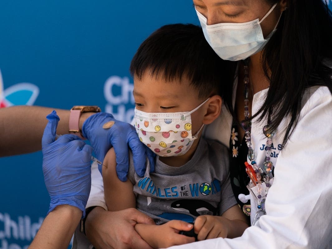 Aevin Lee, 2, receives the Pfizer COVID-19 vaccine in the arms of his mother, Dr. Jennifer Su, at Children's Hospital Los Angeles in Los Angeles, Tuesday, June 21, 2022.