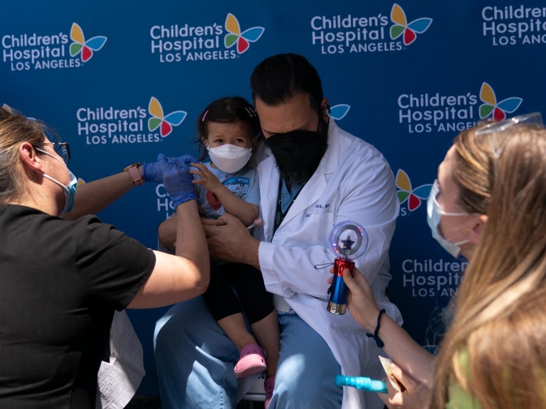 Three-year-old Sofia Espinoza receives the Pfizer COVID-19 vaccine from registered nurse Monica Lopez while sitting on the lap of her father, Dr. Juan Espinoza, at Children's Hospital Los Angeles in Los Angeles, Tuesday, June 21, 2022.