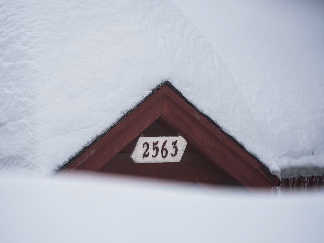Snow is piled up on a home in Running Springs, Calif., Tuesday, Feb. 28, 2023. Beleaguered Californians got hit again Tuesday as a new winter storm moved into the already drenched and snow-plastered state, with blizzard warnings blanketing the mountains.
