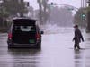 A motorist walks out to remove belongings from his vehicle after becoming stuck in a flooded street, Sunday, Aug. 20, 2023, in Palm Desert, Calif. Forecasters said Tropical Storm Hilary was the first tropical storm to hit Southern California in 84 years.